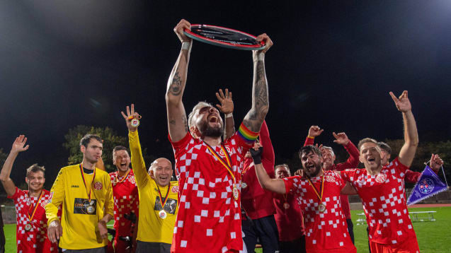 Stefen Schmidt, Kapitän von Mainz 05, reißt die Meisterschale der Amputierten-Fußball-Bundesliga in die Höhe.